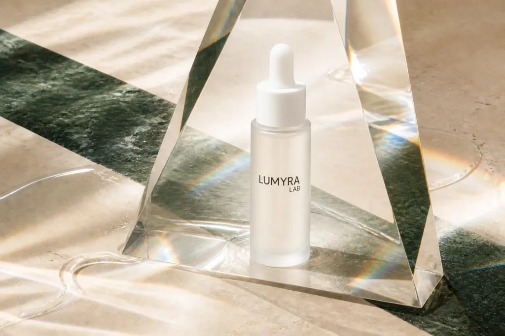 03 Glow Serum framed by prisms and rainbow refractions